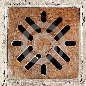Rusty drain grate in concrete floor
