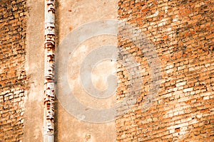 Rusty drainpipe on a brick wall