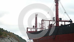 Rusty dry cargo vessel stands near land