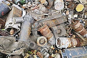 Rusty engines stacked in the scrapyard. Engine parts greased and covered with rust. Dump of pieces of iron and wrecking machinery