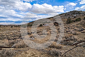 Rusty equipment and abandoned shacks mark the desert hillside of a closed mercury mine in Nevada, USA