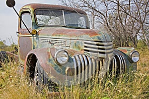 Rusty old farm truck pasture green field