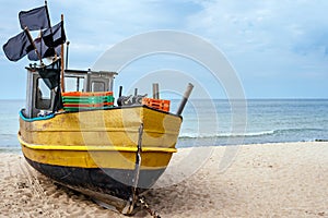Rusty fishing boat and equipment on sandy beach