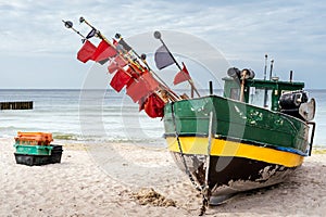 Rusty fishing boat and equipment on sandy beach