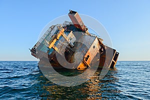 rusty frame of a stranded naval ship in the middle of the sea