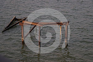 Rusty frame on the water. The unfinished steel frame on the water looks like a harmonious decoration