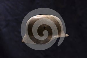 A rusty German World War Two military helmet on dark background