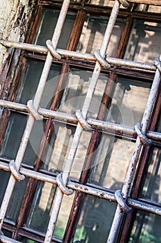 rusty grille on the window in a brick house