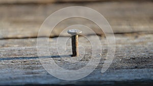 A rusty hammer hammers a nail into the Board