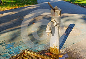 Rusty hand pump of the public water well