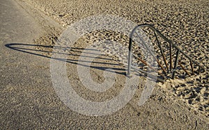 Rusty hand rail on to sand beach