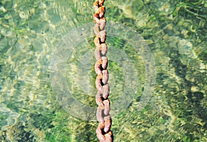 Rusty hard chain, mountains, water natural background