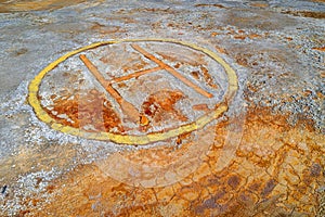 Rusty helipad sign over contaminated ground of abandoned mining area