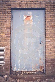 Rusty high voltage warning sign at a old metal door