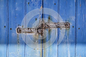 Rusty hinge on Old Blue wooden door in Spain