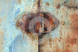 Rusty hinge on old rusted iron door, close-up
