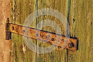 Rusty hinge of an old wooden door of country barn
