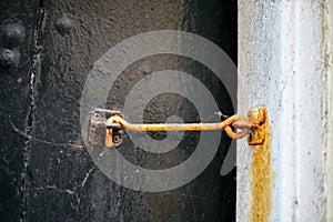 Rusty hook on old wooden door. Close up