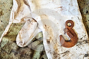 Rusty hook on a protective gloves closeup. Idustrial background with copy space