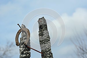 Rusty horseshoes on a burned wooden pole - rustic scene in a country style.