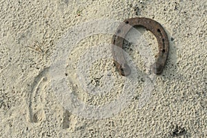 Rusty horseshoes on a sand background - rustic scene in a country style. Old iron Horseshoe - good luck symbol and mascot of well