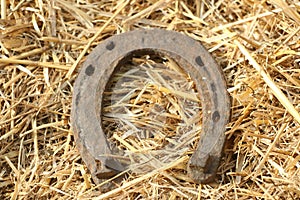 Rusty horseshoes on a straw background - rustic scene in a country style. Old iron Horseshoe - good luck symbol and mascot of well