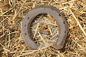 Rusty horseshoes on a straw background - rustic scene in a country style. Old iron Horseshoe - good luck symbol and mascot of well