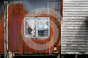 Rusty hovel in slum area in Thailand, house frontage and facade with rusty corrugated sheet and old wood