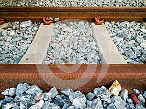 Rusty inactive railroad with concrete sleepers and rocks foundation