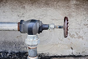 Rusty Industrial Water Pump and Tap on Wall