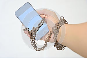Rusty iron chain that ties together hand and smart phone