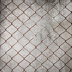 Rusty iron chain wire fence on cement wall