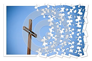 Rusty iron cross against a blue background - Rebuild our faith - Christian cross concept image in jigsaw puzzle shape