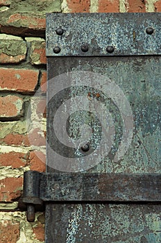 Rusty iron door on brick