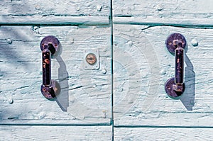 Rusty iron handles on a painted wooden door