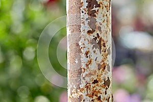 Rusty iron pole as part of a metal fence