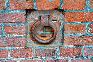 A rusty iron ring in an old brick wall