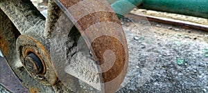 The rusty iron wheel of the old gate of an old abandoned building