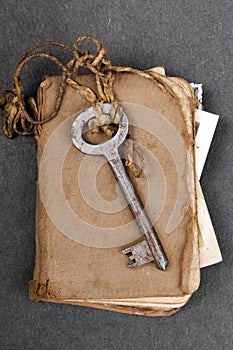 Rusty key and old book on dark background