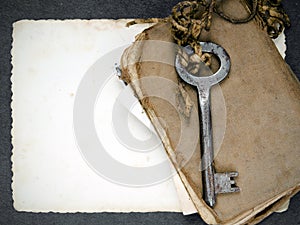 Rusty key, old book and empty photography as a memories metaphor