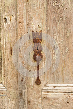 Rusty keyhole on an old weathered wooden door