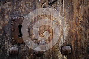 Rusty keyhole in old wooden door