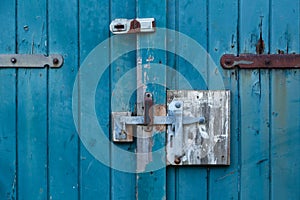 Rusty latch and padlock on old wooden door