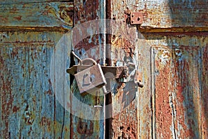 Rusty lock on old wooden gate
