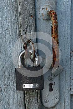A rusty lock weighs on the door