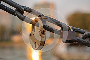 Rusty lover lock on a chain on a bridge, lovers locks on a bridge chain