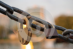 Rusty lovers locks on a chain on a bridge, lovers locks on a bridge chain