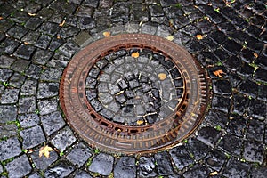 Rusty manhole cap, grunge manhole cover after rain