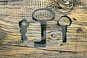 Rusty medieval keys on worn out wood table