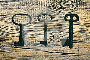 Rusty medieval keys on worn out wood table